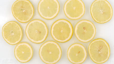 Many-fresh-lemon-top-view-of-water-flowing-on-a-white-background.